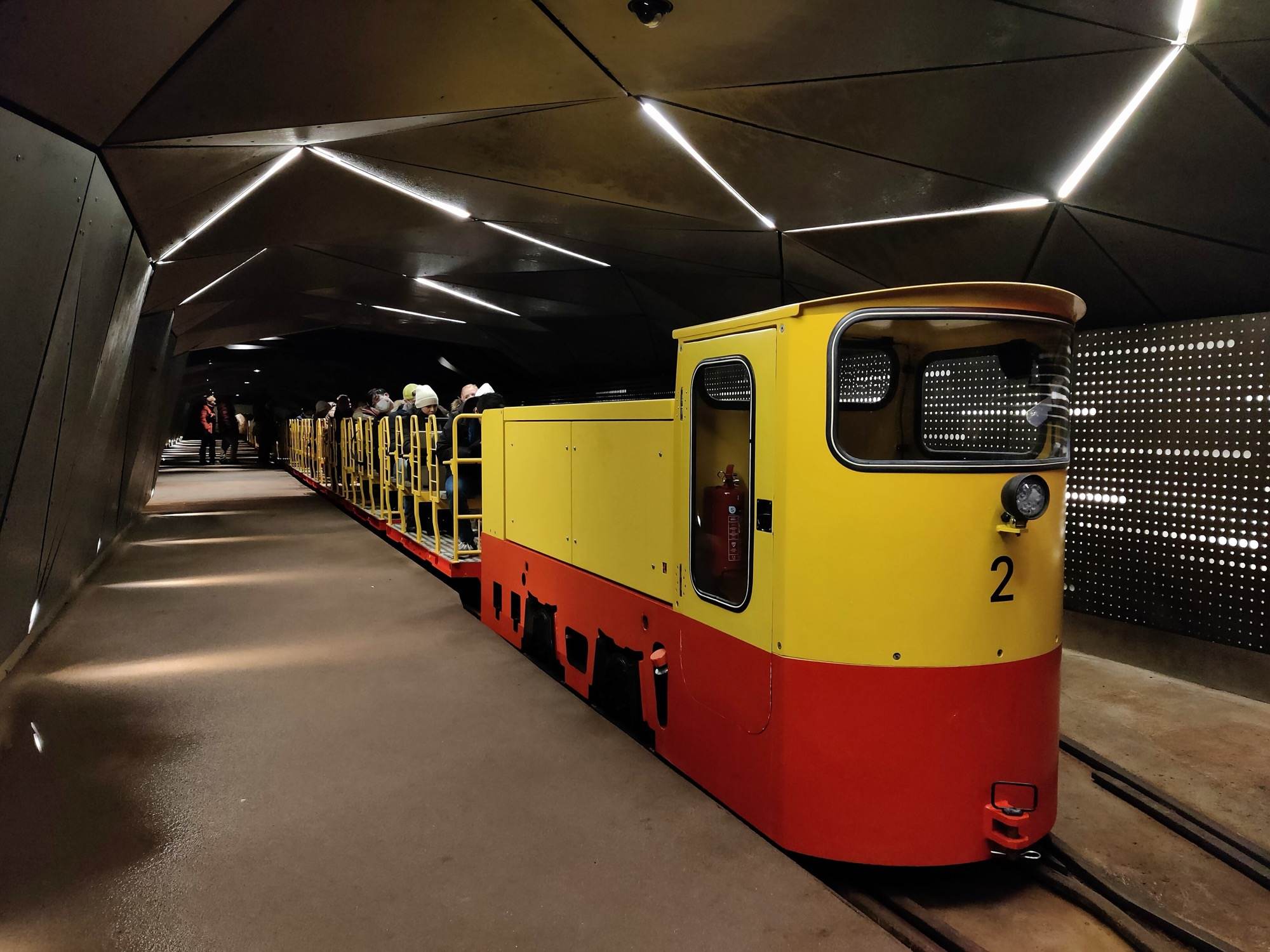 The yellow and red electric cave train waiting at the underground station